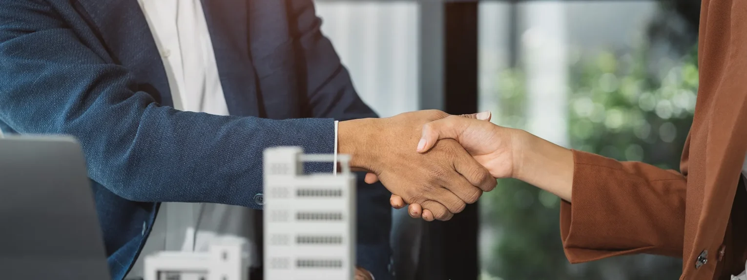 corporate person and building owner shaking hands