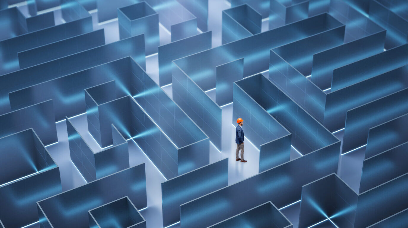 businessman walking through a darkly lit blue maze